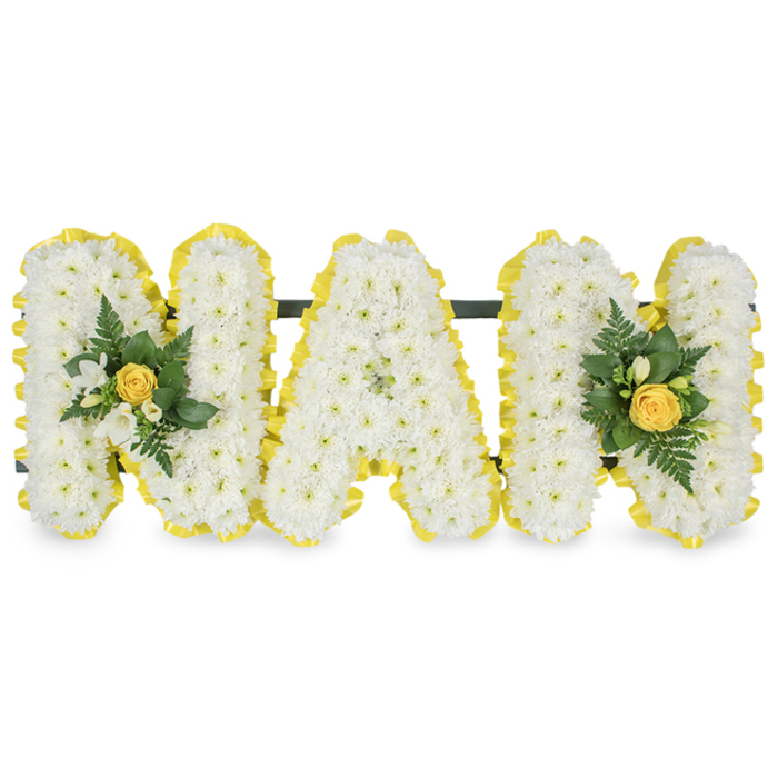 A lovingly personalised sympathy design spells the word 'MAM' in three separate capital letters, each letter fashioned from a dense carpet of small, snow-white chrysanthemum spray blooms to create a tactile, full-bodied surface. Every letter's edge is traced with a bright, sunny yellow satin ribbon that has been pleated and applied with precision, providing a neat finished rim and a cheerful counterpoint to the pristine white centre. Two tasteful floral embellishments have been placed to balance the composition: one sits on the left upright of the first 'M' and the other mirrors it on the right upright of the final 'M'. Each accent cluster centres on a gently furled yellow rosebud, surrounded by delicate white freesia or similar small white buds and layered with deep green, glossy leaves and slender fern fronds to add depth and a verdant freshness. A slim, dark green or black horizontal support bar runs behind the top of the letters to keep them aligned and ready for display on a stand or at a graveside. Photographed against a clean white background, the arrangement's textures, pleated ribbon and subtle leaf shine read clearly and calmly. As Flower Delivery Bexleyheath we often craft pieces like this for families who remember a mother with warmth and simplicity - whether delivered to a service near Bexleyheath Broadway or placed at a local funeral home close to Welling. The result is a composed, hopeful tribute that balances purity and brightness to convey enduring love and remembrance.